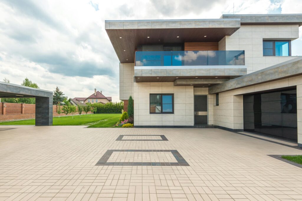pexels-photo-8134850-8134850 Stylish modern house featuring a sleek design with a large driveway and lush greenery.